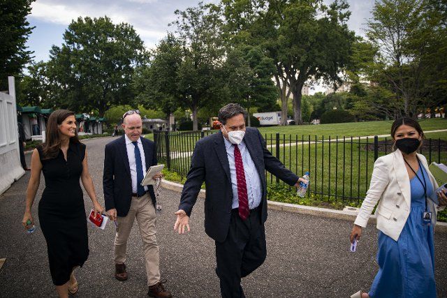 Ron Klain, White House chief of staff, center, reacts to questions from Kaitlan Collins, chief White House correspondent for CNN, left, and Jeff Mason, White House correspondent for Reuters, as he returns to the West Wing with Remi Yamamoto, White House senior advisor for communications for the White House chief of staff, right, following a television interview on the North Lawn of the White House in Washington, D.C., US, on Monday, Aug. 8, 2022. US President Joe Biden resumed official travel today for the first time since his bout with Covid-19, traveling to Kentucky to show federal support for the state\