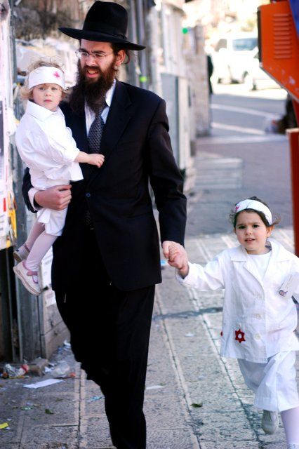 JERUSALEM - MARCH 05: Ultra-orthodox Jewish man and his daughters dressed as nurses celebrates the Jewish holiday Purim on March 05 2007 in Mea Shearim in Jerusalem, Israel