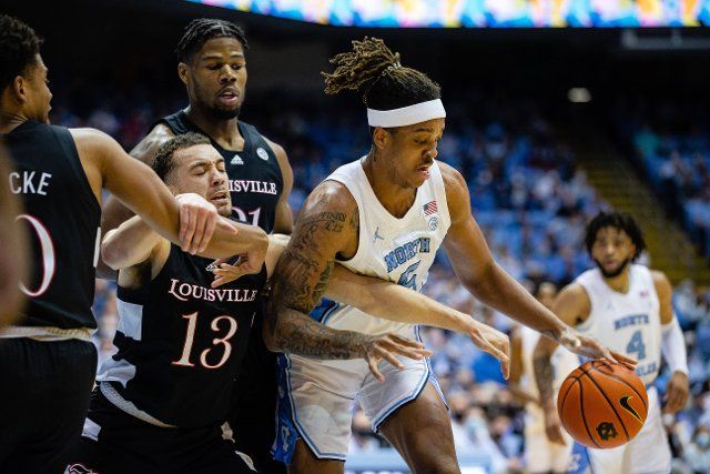 February 21, 2022: Louisville Cardinals guard Jarrod West (13) and North Carolina Tar Heels forward Armando Bacot (5) go for a loose ball during the first half of the ACC basketball matchup at Dean Smith Center in Chapel Hill, NC. (Scott Kinser\/Cal Sport Media