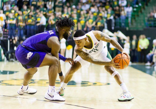 February 19 2022: Baylor Bears guard James Akinjo (11) holds the ball against TCU Horned Frogs guard Mike Miles (1) during the 2nd half of the NCAA Basketball game between the TCU Horned Frogs and Baylor Bears at Ferrell Center in Waco, Texas. Matthew Lynch