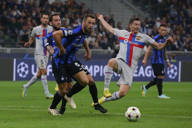 October 4, 2022, Milan, United Kingdom: Milan, Italy, 4th October 2022. Robert Lewandowski of FC Barcelona is ousted aside by Hakan Calhanoglu of FC Internazionale as team ate Stefan de Vrij of FC Internazionale clears the ball during the UEFA Champions League Group C match at Giuseppe Meazza, Milan
