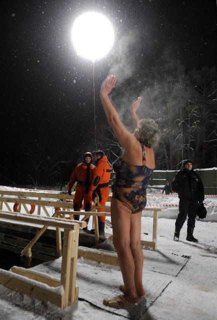 A woman stands with her arms in the air after taking a dip in an ice hole in Serebryany Bor forest park, on the eve of the Feast of Theophany (Epiphany) in Moscow, Russia on January 18, 2013. Photo by Sergei Bobylev\/Itar-Tass\/ABACAPRESS.COM