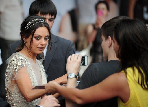 Hollywood actor Mila Kunis (L) signs autograph at the Moscow premiere of Screen Gems and Castle Rock Entertainment\