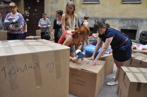 Volunteers wrap boxes of donated clothes at a humanitarian aid collection point for flood victims in Krymsk. St Petersburg, Russia, July 10, 2012. Photo by Yelena Palm\/Itar-Tass\/ABACAPRESS.COM