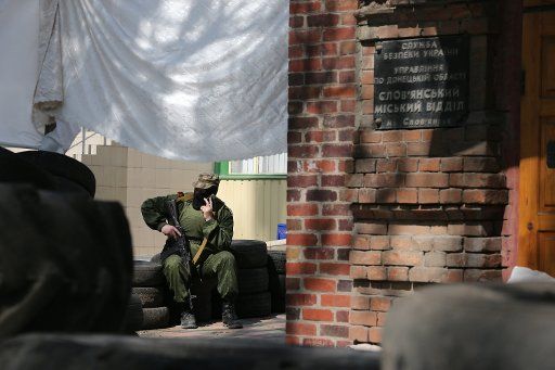 A member of Donbass self defense units outside the Ukraine Security Service building in the town of Slavyansk, Donetsk Region, eastern Ukraine. Slavyansk, East Ukraine, April 23, 2014. Photo by Mikhail Pochuyev\/Itar-Tass\/ABACAPRESS.