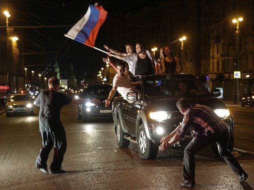 Russian fans with their national flag celebrate a 5-2 victory of the Russian ice hockey team over Finland in the 2014 IIHF World Championship final in a city streetin Russia on May 26, 2014. Photo by Sergei Savostyanov\/Itar-Tass\/ABACAPRESS.
