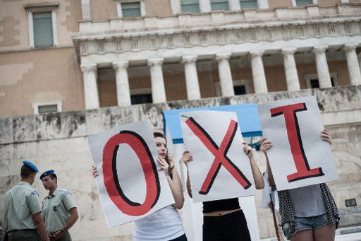 Leftist youths hold placards outside the Greek parliament reading "NO" during a demonstration supporting the Greece\