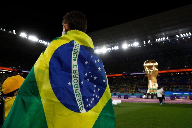 28th November 2022; Stadium 974, Doha, Qatar; FIFA World Cup Football, Brazil versus Switzerland; Brazil mascot wearing the Brazil flag as a cape watches the Brazil team walk onto the pitch