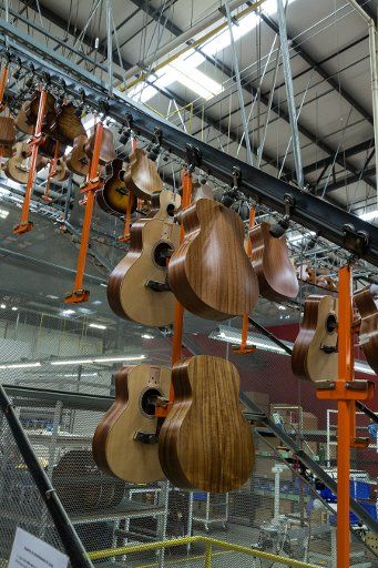 Guitar bodies are placed on an automated carousel running around the ceiling of the factory to save storage space while the newly glued bridges dry in the Taylor Guitar factory in Tecate, Mexico