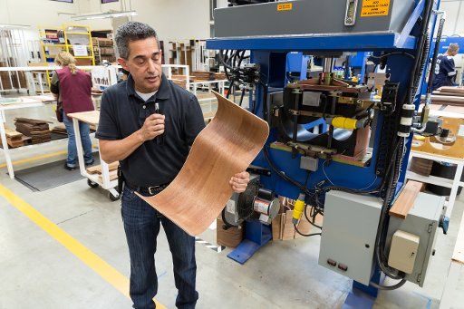 The manager of the Taylor Guitar factory in Tecate, Mexico, explains how guitar sides are shaped with heat and pressure. The hydraulic press for shaping the wood pieces is in the background