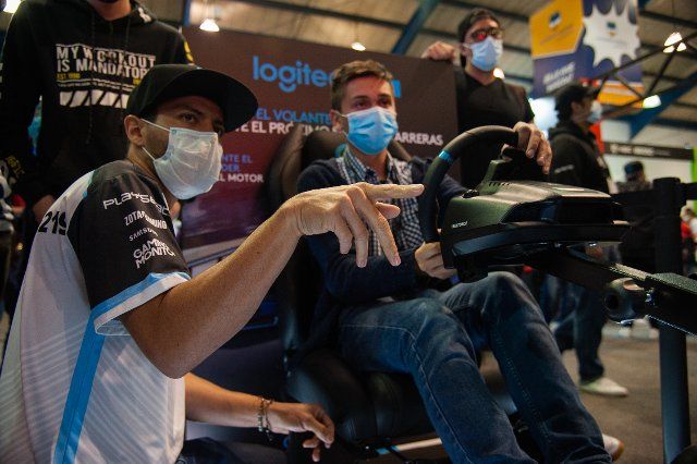 People play and enjoy a driving simulator from Logitech during the fourth day of the SOFA (Salon del Ocio y la Fantasia) 2021, a fair aimed to the geek audience in Colombia that mixes Cosplay, gaming, superhero and movie fans from across Colombia, in Bogota, Colombia on October 17, 2021