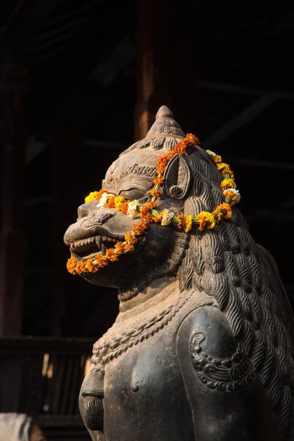 A bronze statue of Hanuman adorned with a marigold garland in the Krishna Temple in Durbar Square, Kathamandu, Nepal