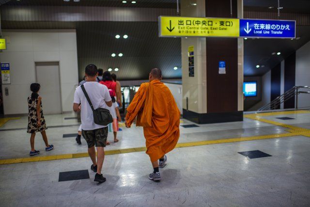 Buddhist monk and other people in train