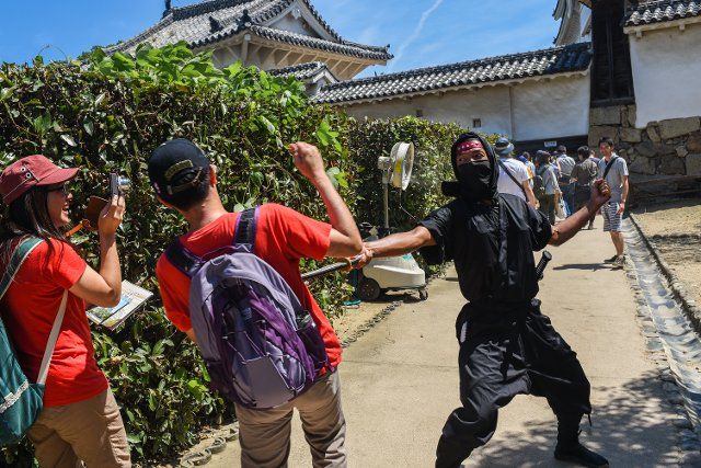 A man dressed as a ninja welcomes tourists to Himeji Castle (HimejijÅ), also known as White Heron Castle, is Japanâs best preserved feudal