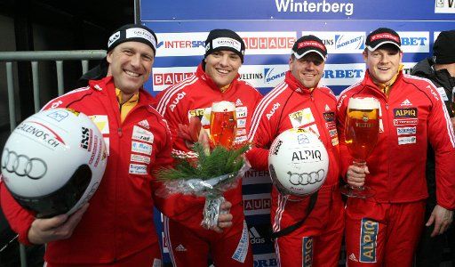 Swiss Beat Hefti (2-R) and Thomas Lamparter (R) celebrate their victory at the 2-Men Bob competition at the Bobsleigh World Cup 2009 in Winterberg Germany 12 December 2009. Swiss Ivo Rueegg (L) and Roman Handschin finished third. Photo: JULIAN ...