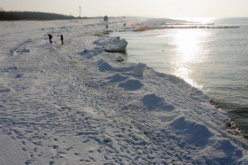 People walk on the icy and snowy beach on the peninsula Fischland near wustrow Germany 05 February 2010. Photo: BERND