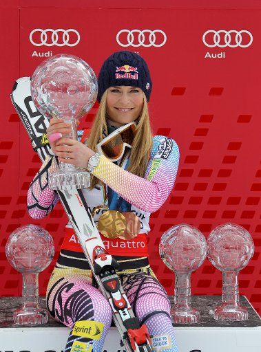 The winner of the overall world cup US Lindsey Vonn poses on the podium with her Olympic medals from Vancouver and her collected World Cup Trophies during the World Cup Final in Garmisch-Partenkirchen Germany 13 March 2010. Photo: STEPHAN