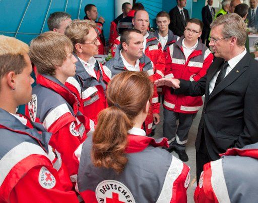 The Federal President Christian Wulff (R) talks to rescue workers of the German Red Cross (DRK) after the Memorial Service for the victims of the Love Parade tragedy in Duisburg Germany 31 July 2010. The victims\