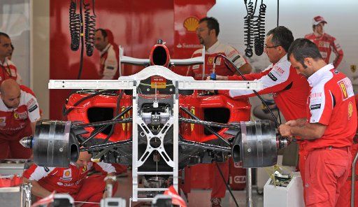 Ferrari mechanics work on Fernando Alonso\