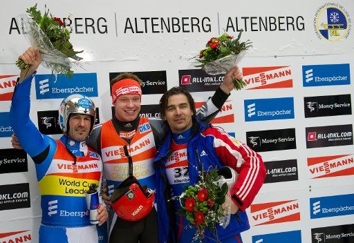 Runner-up Armin Zoeggeler from Italy (l-r) German winner Felix Loch and third-place winner Albert Demchenko from Russia attend the medal ceremony at the luge world cup in Altenberg Germany 23 January 2011. Photo: Arno