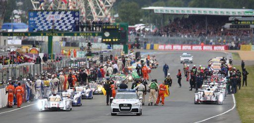 The racing cars with LMP1 class Audi R18 e-tron quattro hybrid of Audi Sport Team Joest with drivers Andre Lotterer, Marcel Faessler and Benoit Treluyer (L) line up for the start of the 80th 24 Hours Race of Le Mans on the Circuit de la Sarthe in Le ...