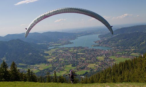A paraglider takes off from Wallberg near Tegernsee, Germany, 16 June 2012. Tegernsee Lake is pictured in the background. Photo: Sven