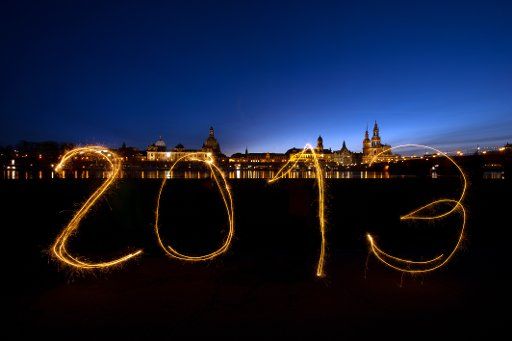 (ILLUSTRATION) An illustration dated 28 December 2012 shows the number of the year 2013 drawn by four people with sparklers in front of the skyline of Dresden, Germany (bulb exposure). Photo: ARNO 