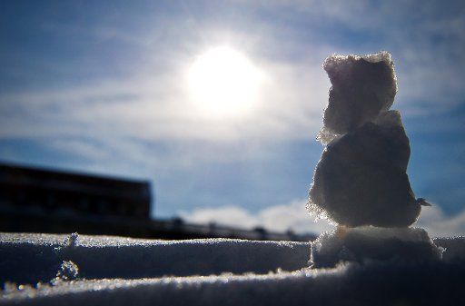 A little snowman is situated on a snow-covered hedge on a sunny day in Berlin, Germany, 13 march 2013. Photo: Jan-Philipp