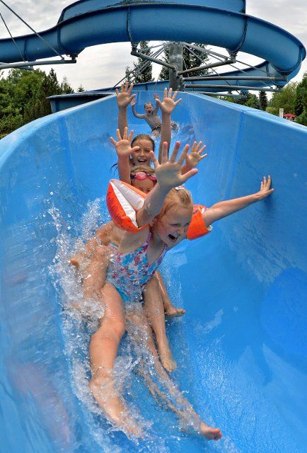 Children slide down the 75 m long waterslide in the bath of Rebesgruen, Germany, 24 July 2013. This weekend the 17th German water sliding championship will take place in the bath. Photo: HENDRIK