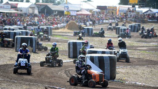 People race along a course with their lawn movers on a field near Thoense, Germany, 25 August 2013. Photo: PETER