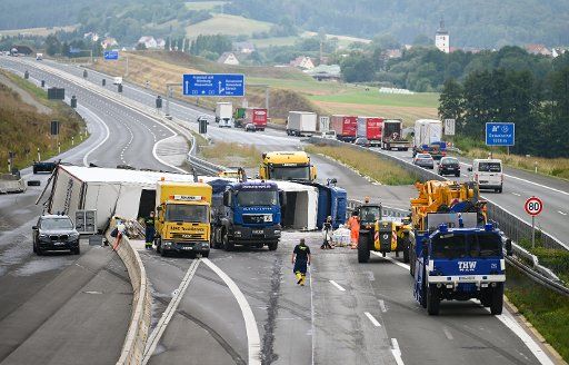 07 August 2019, Bavaria, Geiselwind: An overturned truck lies across the A3 motorway. Due to an overturned truck, the Autobahn 3 at Geiselwind (district of Kitzingen) in the direction of Nuremberg has been closed. According to police, the truck, loaded with paint, overturned at a construction site on Wednesday morning. Photo: Nicolas Armer\/