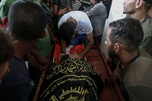 18 August 2019, Palestinian Territories, Jabalya camp: Palestinian mourners surround the body of Mahmoud al-Walidah, one of the three Palestinians who were shot by Israeli soldiers overnight along the border with Israel, during his funeral. Photo: Mohammed Talatene\/