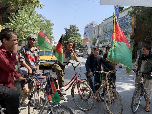 19 August 2019, Afghanistan, Kabul: Afghan boys ride their bikes decorated with the country\