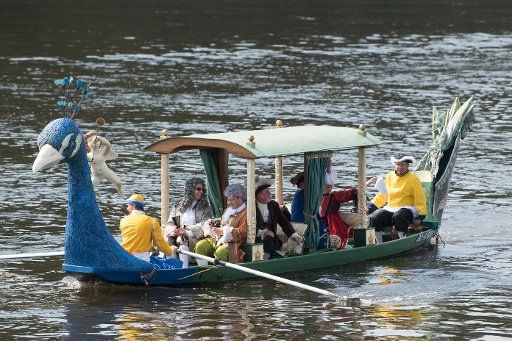 25 August 2019, Saxony, Dresden: Lay actors in baroque costumes ride in a baroque pleasure gondola on the Elbe. The 300th anniversary of the wedding of the Saxon Elector Friedrich August II with the Emperor\