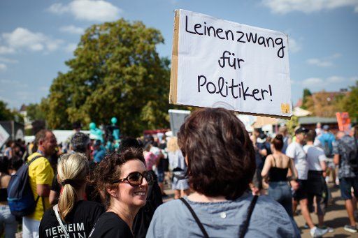 24 August 2019, Berlin: Participants run along with a self-painted sign ("Leinenzwang für Politiker!") on the technoparade "Zug der Liebe". The organizers of the demonstration would like to promote more social commitment and charity. Photo: Gregor Fischer\/