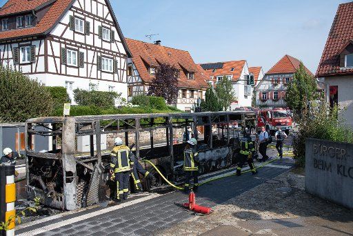 09 July 2019, Germany (German), Kusterdingen: Firefighters extinguish a fire in a bus. (to dpa: "Bus burnt out" Photo: Wolfgang Frank\/