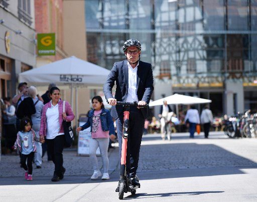 10 July 2019, Thuringia, Erfurt: Georg Maier (SPD), Minister of the Interior of Thuringia, drives through the city centre on an electric pedal scooter. In a press conference on the same day, he wants to draw attention to various aspects of road safety. Photo: Martin Schutt\/dpa-Zentralbild\/