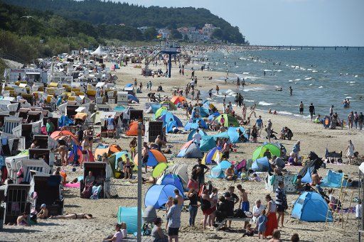 11 July 2019, Mecklenburg-Western Pomerania, Heringsdorf: Numerous tourists seek cooling in sunny weather at the Baltic Sea on the island of Usedom. Photo: Stefan Sauer\/dpa-Zentralbild\/