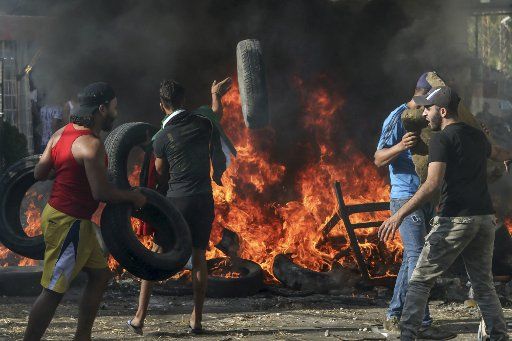 16 July 2019, Lebanon, Ain al-Hilweh: Palestinian refugees burn tires during a protest blocking the entrance of Ain al-Hilweh refugee camp against a decision by the Lebanese government to impose restrictions on their work opportunities. Photo: Str\/