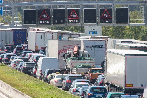 23 July 2019, Bavaria, Munich: At temperatures around 30 degrees Celsius, cars and many trucks are parked close together on the A9 motorway near Munich in the south direction. Photo: Peter Kneffel\/