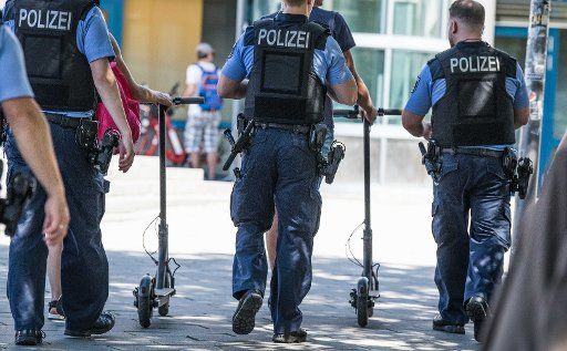 24 July 2019, Berlin: Police officers "escort" two e-scooter drivers. Photo: Jörg Carstensen\/