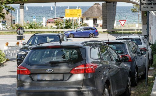 24 July 2019, Schleswig-Holstein, Scharbeutz: Vehicles park halfway down a bend in the road. (To dpa-Korr "bathing resorts in a dilemma, with nice weather the number of wrong parkers rises") Photo: Markus Scholz\/