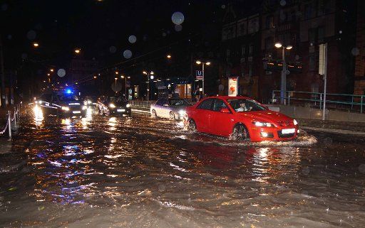 26 July 2019, Stuttgart: The Pragstraße B10 in Bad Cannstatt is 30cm under water, a roadway is closed by the police. Severe storms have flooded several streets in the Stuttgart area. Photo: Andreas Rosar Fotoagentur-Stuttgart\/