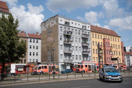 27 July 2019, Berlin: Firefighters are standing on the roof of an apartment building in Danziger Straße. A fire had broken out in an attic apartment of the building. Photo: Jörg Carstensen\/