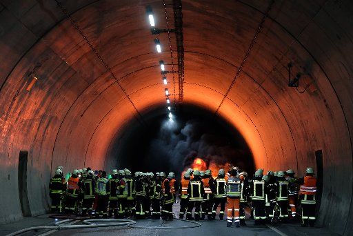 28 September 2019, Thuringia, Breitenworbis: Firefighters are standing in a simulated fire in the Höllberg tunnel on the A 38. In road tunnels, large-scale exercises have to be carried out every four years to train the cooperation between rescue services and authorities in the event of a disaster. The five-hour exercise involved 150 people and 35 vehicles. Photo: Sebastian Willnow\/dpa-Zentralbild\/