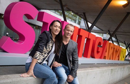 03 October 2019, Baden-Wuerttemberg, Stuttgart: Gymnastics: WM, kick-off-Pk. The World Championship ambassadors Catalina Ponor (l) from Romania and Fabian Hambüchen from Germany are sitting in front of the Hanns-Martin-Schleyer-Halle in front of a Stuttgart2019 lettering. Photo: Marijan Murat\/