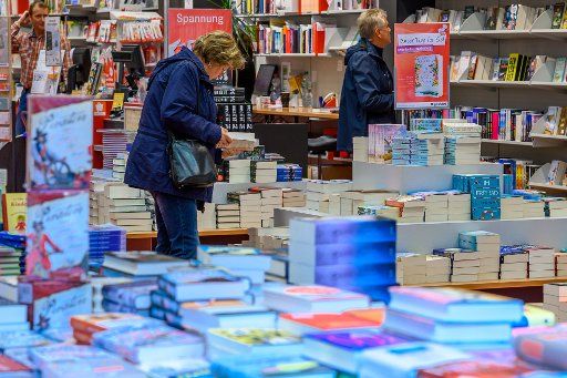 17 September 2019, Mecklenburg-Western Pomerania, Schwerin: A customer is leafing through a novel in a bookstore. Since 2005, the German Publishers and Booksellers Association (Börsenverein des Deutschen Buchhandels) has annually awarded the German Book Prize to the best German-language novel of the year. The prize is endowed with a total of 37,500 euros. Photo: Jens Büttner\/dpa-Zentralbild\/