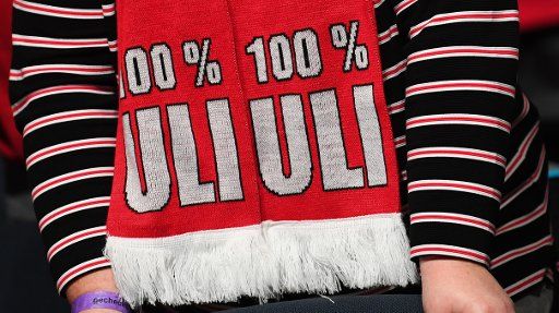 15 November 2019, Bavaria, Munich: Soccer: Bundesliga, Annual General Meeting FC Bayern Munich in the Olympiahalle. A member wears a scarf with the inscription "100% Uli" before the annual general meeting. Photo: Sven Hoppe\/