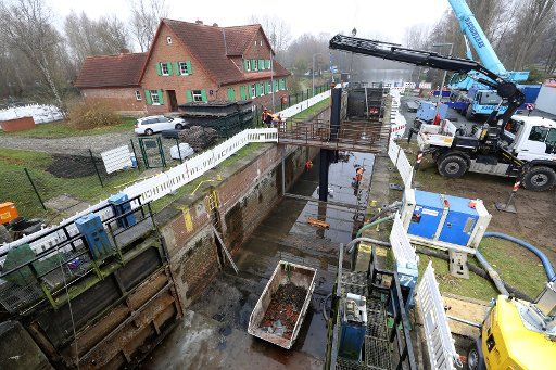 25 November 2019, Mecklenburg-Western Pomerania, Rostock: Workers are standing in the drained Mühlendammschleuse. The building inspection will be continued at the Mühlendammschleuse, which has been out of operation since 2011. After completion of the inspection, a sheet pile wall and a dam body will be built in the lock to secure the site for flood protection and drinking water supply from the Warnow. The city can then decide how to proceed with the lock, which is then no longer in the care of the Federal Waterways and Shipping Administration. Photo: Bernd Wüstneck\/dpa-Zentralbild\/