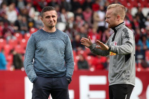 27 October 2019, Bavaria, Nuremberg: Soccer: 2nd Bundesliga, 1st FC Nuremberg - Jahn Regensburg, 11th matchday in Max Morlock Stadium. Regensburg coach Mersad Selimbegovic (l) talks to co-trainer Jonas Maier before the match begins. Photo: Daniel Karmann\/dpa - IMPORTANT NOTE: In accordance with the requirements of the DFL Deutsche Fußball Liga or the DFB Deutscher Fußball-Bund, it is prohibited to use or have used photographs taken in the stadium and\/or the match in the form of sequence images and\/or video-like photo sequences.